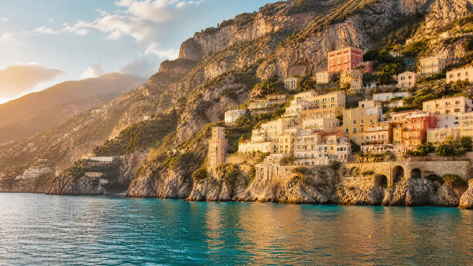The Amalfi coast in full daylight: coral rooftops, ochre cliffs and a turquoise sea